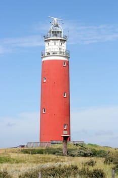 red lighthouse with blue sky in the background.