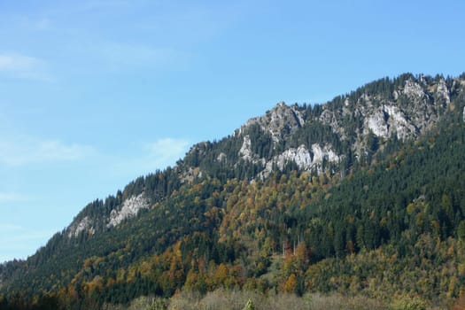 A landscape in the highlands, with rocks, trees and blue sky.