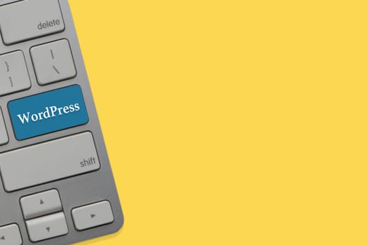 WORDPRESS text on keyboard over yellow background. Business and technology concept