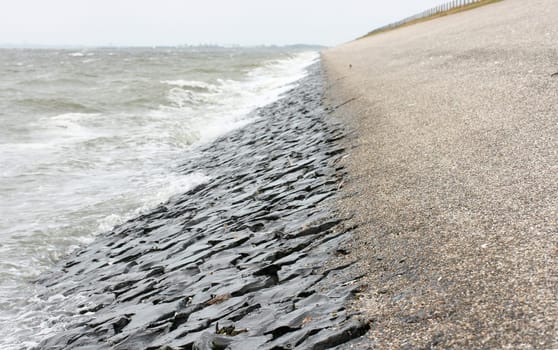 Detail view of a dam fortified with stones on the North Sea .