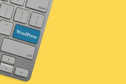 WORDPRESS text on keyboard over yellow background. Business and technology concept