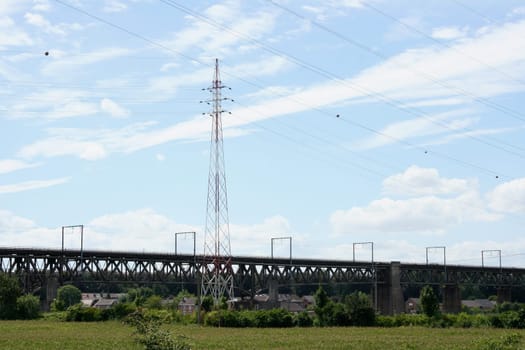 Large steel railway bridge, blue sky in the background .
