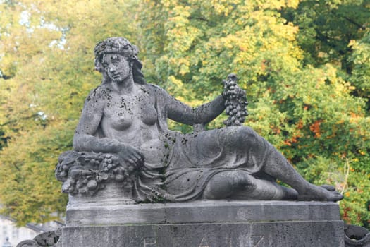 The statue of a naked woman lying with grapes in his hand.