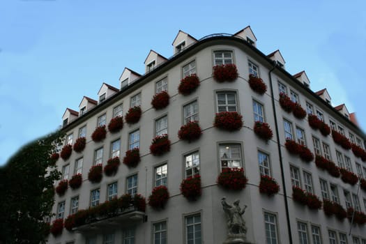 Multi-storey with flowers on each window .