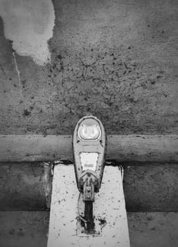 Close up of a LED electric street lamp, black and white moody street photography. Rusty and dirty outdoor urban architecture details, aged concrete structure elements.
