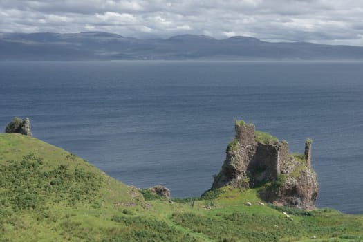 Old ruined coastal castle, brochel castle, on the shores of the inner sound and isle of Raasay in scotland. Sunny day with a cloudy sky.
