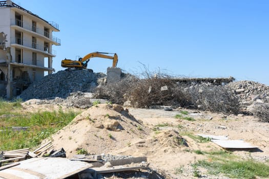 Excavator with hydraulic hammer dismantling a building