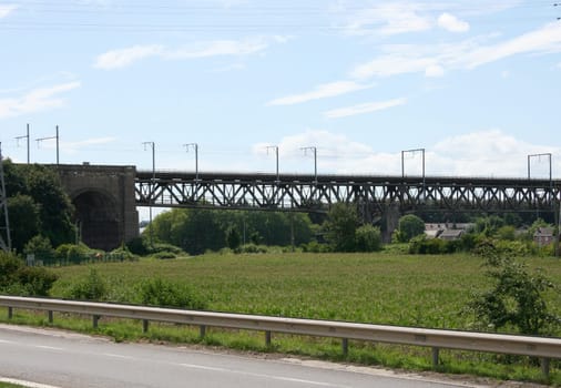 Large steel railway bridge, blue sky in the background .