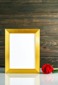 Picture mock up with golden frame and red roses flowers on table with copy space
