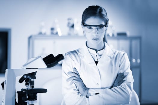 Portrait of a attractive, young, confident female health care professional in hes working environment. Blue toned black and white image.
