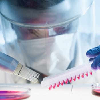 Scientist working in the corona virus vaccine development laboratory research with a highest degree of protection gear. Coronavirus pandemic concept. Development of virus treatment drug.