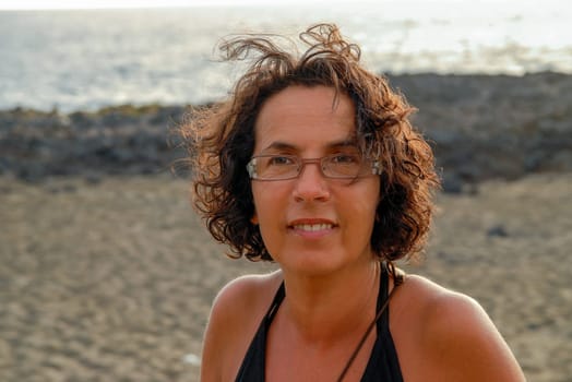 a portrait of beautiful tanned mature brunette with eyeglasses