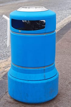 Blue plastic trash bin at street