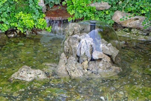 Small pond with waterfall in backyard