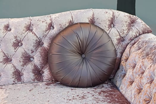 Round leather pillow at upholster sofa