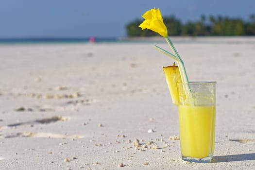Yellow pineapple juice at sand beach