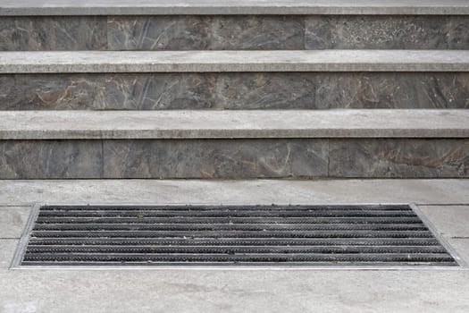 Built in doormat in front of marble stone stairs