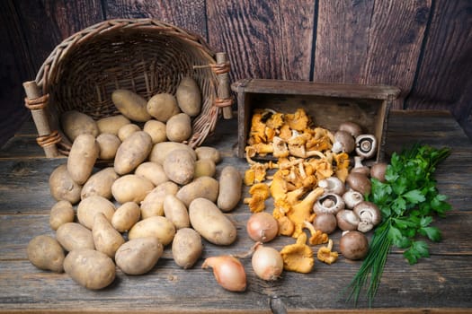 Potatoes, mushrooms,parsley,chive and onions on a wooden table