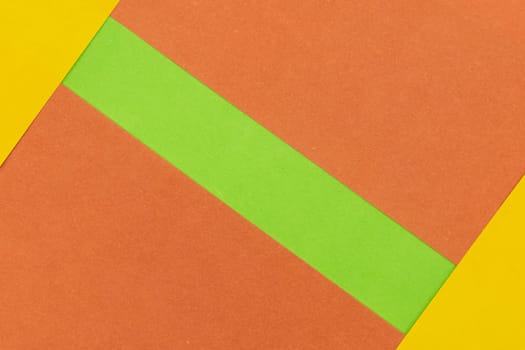 Green, Orange and Yellow coloured paper background, abstract contrast conceptual image