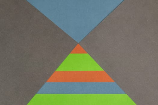 Green, Orange, Blue and Grey coloured paper background, abstract contrast conceptual image