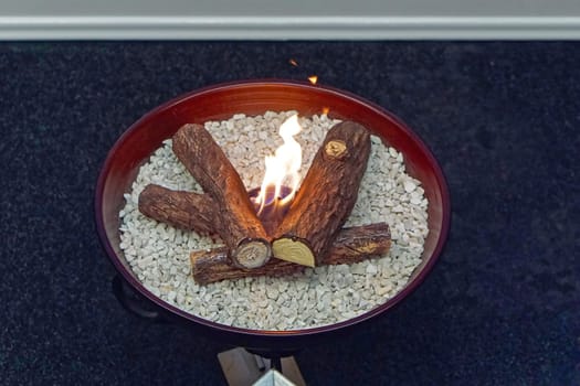 Artificial fire in round tray at home
