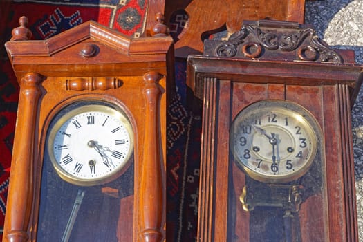 Two wooden grandfather clocks with pendulum at flea market