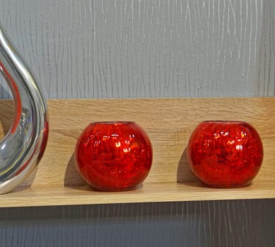 Two red glass scented candles at shelf decor