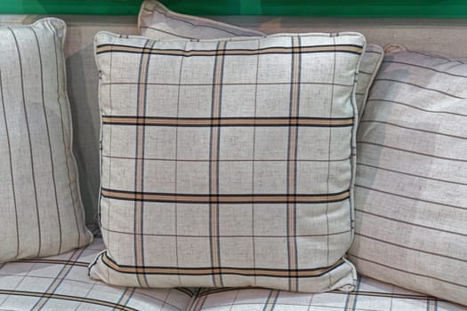 Decorative plaid textile pillows at sofa