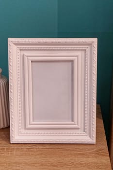 White portrait picture frame at night table