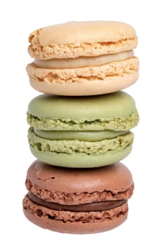 Pastries, desserts and sweets. Close-up of a yellow french vanilla macaroon, a green pistachio macaroon and a brown chocolate macaroon isolated on a white background. Macro photograph.