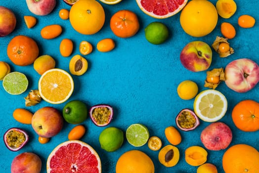 Flat lay layout of summer and citrus fruits on blue background. Healthy eating concept.