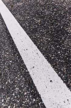 Old asphalt road with separation line. Selective focus.