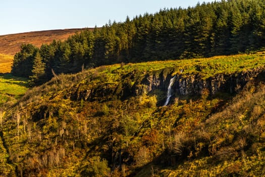 Beautiful waterfall and stream in the valley of Glenariff Forest Park in autumn colours, Count Antrim, Northern Ireland
