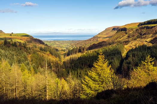 Panoramic view on the valley of Glenariff Forest Park in autumn colours with Scotland shore in far distance, Count Antrim, Northern Ireland