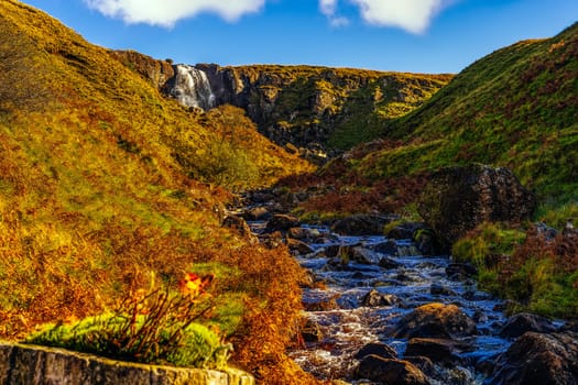 Beautiful waterfall and stream in the valley of Glenariff Forest Park in autumn colours, Count Antrim, Northern Ireland