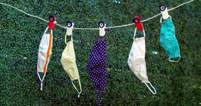 Drying outside reusable family face masks, hang on a clothesline nylon rope with clothespins.