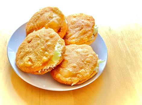 A plate with A close up of a Gordita "chubby"" in Spanish is a Mexican cuisine is a pastry made with maize dough and stuffed with cheese, meat, or other fillings."