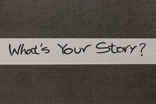White and Grey coloured paper background with Whats Your Story motivational handwritten message