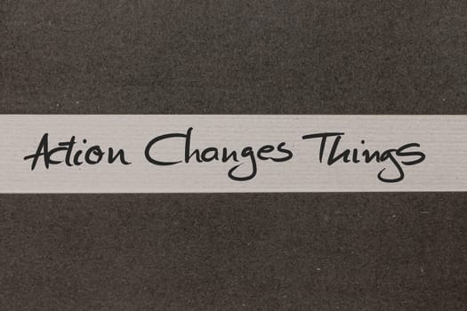 White and Grey coloured paper background with Action Changes Things motivational handwritten message