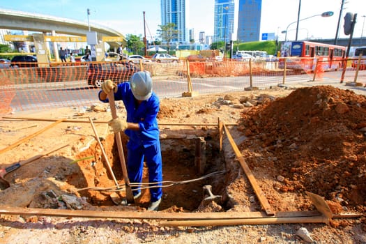 salvador, bahia / brazil - december 5, 2013: worker is building a walkway in the city of Salvador...