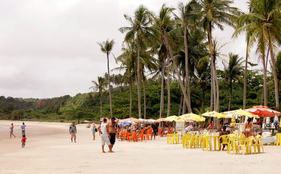porto Seguro, bahia / brazil - january 7, 2011: people are seen sitting next to chairs on the beach of Trancoso in the city of Porto Seguro, in the south of Bahia.