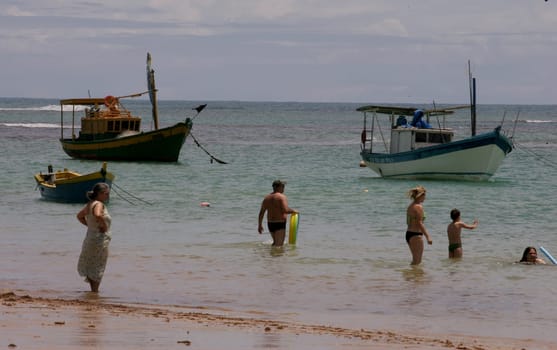 porto seguro, bahia / brazil - january 7, 2011: Fishing boat is seen with people on the beach in the city of Porto Seguro, in southern Bahia.