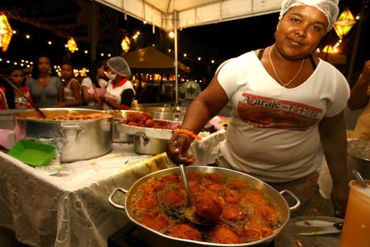 ilheus, bahia / brazil - june 24, 2011: seller of acaraje is seen frying the dumplings in palm oil in the city of Iheus, in the south of Bahia.