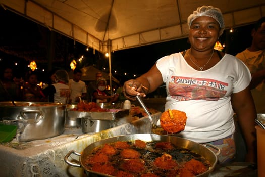 ilheus, bahia / brazil - june 24, 2011: seller of acaraje is seen frying the dumplings in palm oil in the city of Iheus, in the south of Bahia.