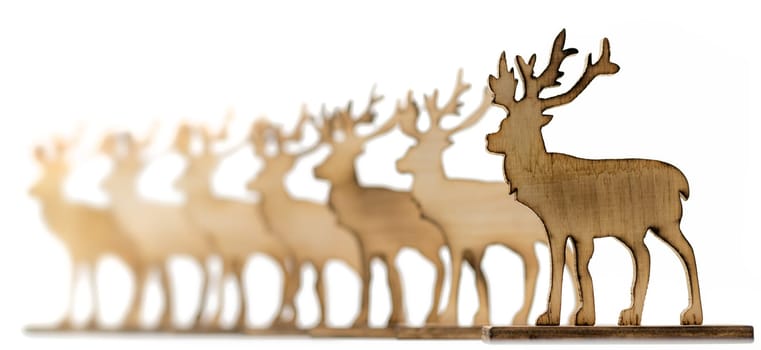 Cut out deer figure made of wood with dark edges and wooden fir trees isolated on white