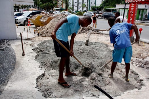 salvador, bahia / brazil - april 3, 2014: people are seen working to repair damaged sidewalk in the pituba neighborhood in the city of Salvador.