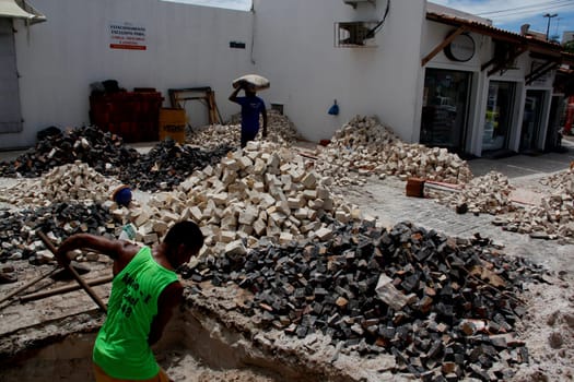 salvador, bahia / brazil - april 3, 2014: people are seen working to repair damaged sidewalk in the pituba neighborhood in the city of Salvador.