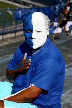itabuna, bahia / brazil - june 11, 2011: a soccer fan paints his face with the colors of his best friend in the city of Itabuna.