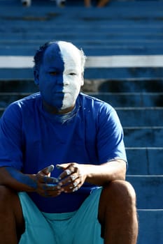 itabuna, bahia / brazil - june 11, 2011: a soccer fan paints his face with the colors of his best friend in the city of Itabuna.