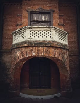 Architecture details, the front door with the balcony of the Hunting Castle at Manuc Bei mansion, Moldova. Old brick building facade. Halloween haunted house concept, ghost home.